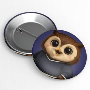 May include: A button badge featuring a cartoon owl with large eyes and a friendly expression. The owl has brown and beige feathers and wears a navy blue sweater. The badge has a metallic back.