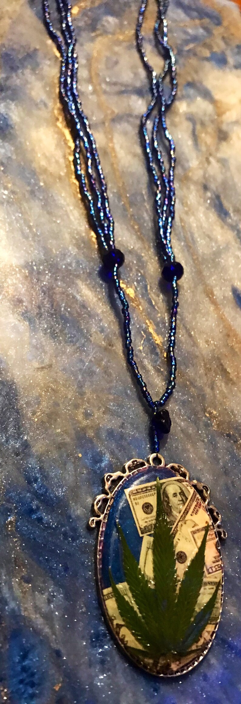 Money necklace with real marijuana leaf on 3 strand blue iridescent bead necklace with crystal accent beads