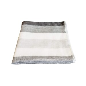 May include: A white and gray striped throw blanket with a gray border.