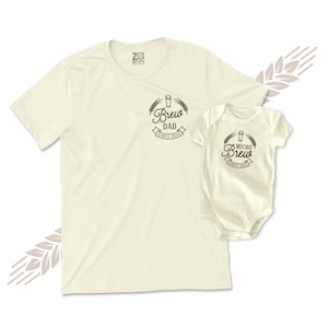 May include: A set of two cream-coloured t-shirts with a beer-themed design. The larger shirt says "Brew Dad Since 2024" and the smaller shirt says "Micro Brew Since 2024".