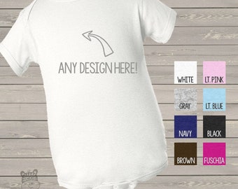 May include: White baby onesie with a gray arrow pointing to the left and the text "ANY DESIGN HERE!" in gray.  The onesie is shown against a woodgrain background.  Below the onesie are color swatches for the onesie in white, light pink, gray, light blue, navy, black, brown, and fuchsia.