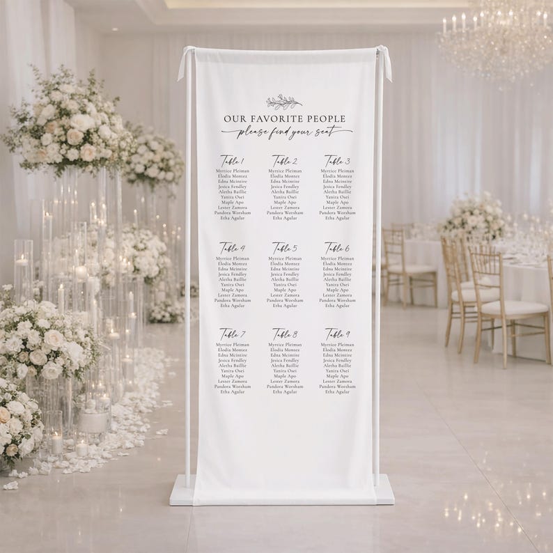 Pu&ograve; includere: Un alto banner verticale in tessuto bianco montato su una cornice in metallo bianco, che mostra il testo "OUR FAVORITE PEOPLE please find your seat" in alto, seguito da nove colonne di nomi degli ospiti sotto "Table 1" fino a "Table 9".