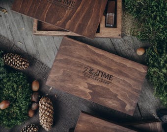 May include: A wooden box with a dark brown finish and the text "Photo Time Photographer" engraved on the lid. The box is open and a small wooden box with a USB drive inside is visible.