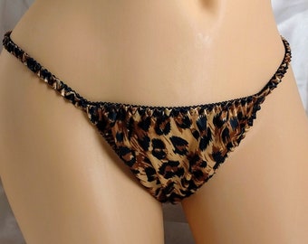May include: Leopard print satin lingerie with black trim. The lingerie is a low-rise style with a cheeky cut.