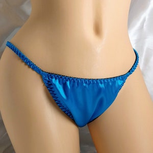 May include: A turquoise blue satin lingerie with black trim. The lingerie is a low-rise style with a thin strap design.