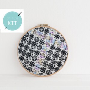 Peut inclure: Un cercle de broderie blanc avec un motif floral noir et blanc. Le cercle est sur une surface blanche. Le texte "Stitch Kit" est dans un cercle bleu avec une aiguille et du fil.
