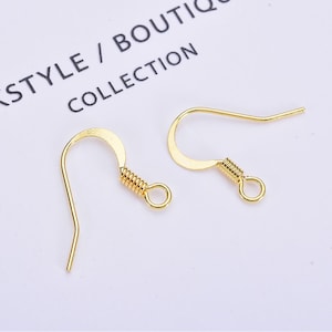 May include: Two gold-toned earring hooks with a spring closure. The hooks are made of metal and are designed for hanging earrings.