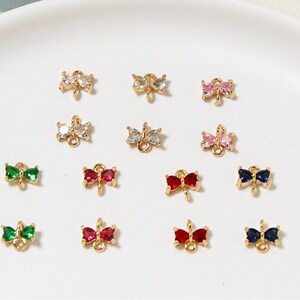 May include: Assortment of gold butterfly charms with various colored crystal accents. The charms have a loop for attaching to jewelry or other crafts.