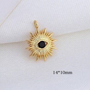 May include: Gold-toned pendant charm with a black evil eye design. The charm is shaped like a sunburst with a black gemstone in the center. The charm measures 14mm by 10mm.