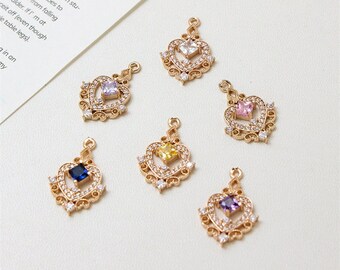 May include: Six gold heart-shaped pendants with different colored gemstones in the center. Each pendant has a delicate filigree design and is adorned with small clear rhinestones.