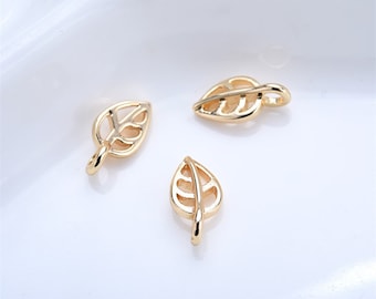 May include: Three gold leaf charms with a delicate, openwork design. These charms are perfect for adding a touch of nature to jewelry projects.