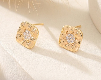 May include: Gold tone square stud earrings with a star design set with clear cubic zirconia stones.