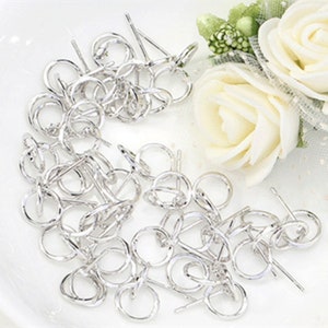 May include: A close-up of a pile of silver earring findings. The findings are small, round, and have a post on the back. They are perfect for making your own earrings.