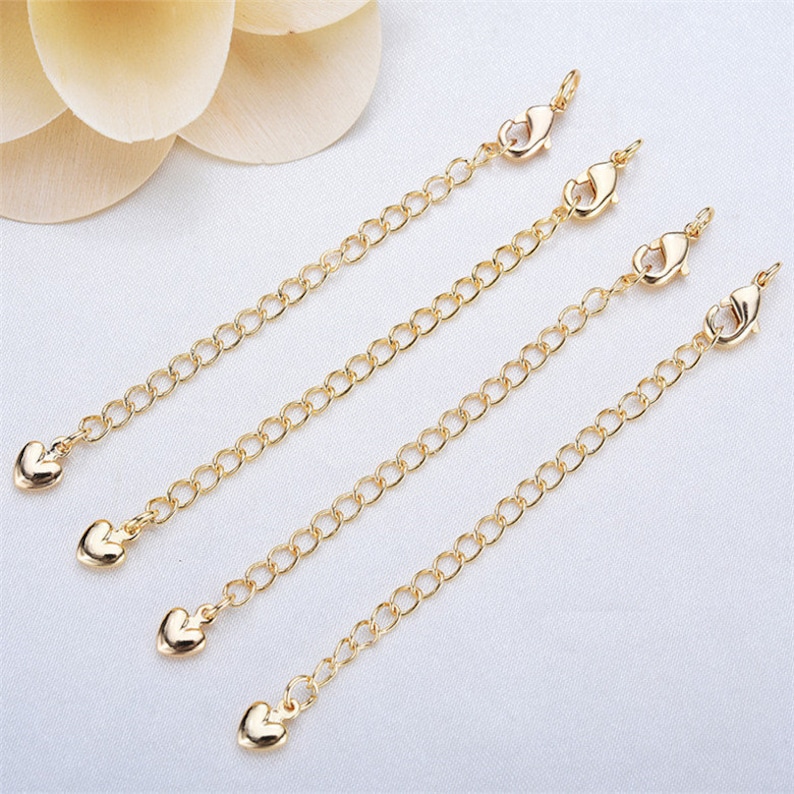 May include: Four gold-tone extender chains with heart-shaped charms and lobster claw clasps. Each chain is approximately 2 inches long.