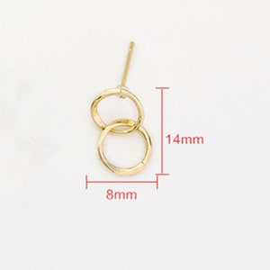 May include: Gold-toned double circle earrings with a post back. The earrings measure 14mm in length and 8mm in width.