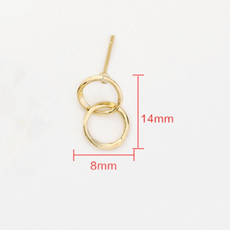May include: Gold-toned double circle earrings with a post back. The earrings measure 14mm in length and 8mm in width.
