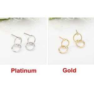 May include: Two pairs of double circle earrings, one pair in silver and one pair in gold.