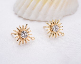 May include: Gold-tone earring with a clear crystal in the center and a starburst design. The earring has a small loop on the side for attaching a charm.