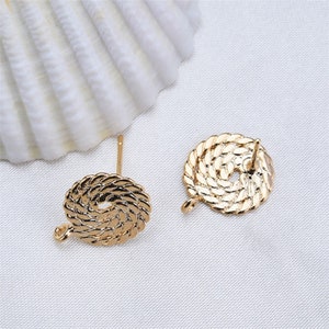 May include: Two gold-tone earring findings with a rope-like design. Each finding has a loop on one side and a post on the other.