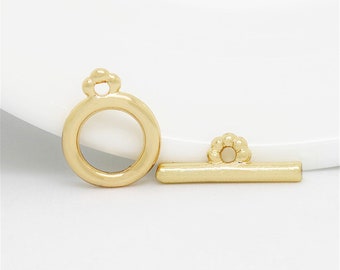 May include: Gold-toned metal clasp with a round loop and a straight bar. The clasp is designed for jewelry making.