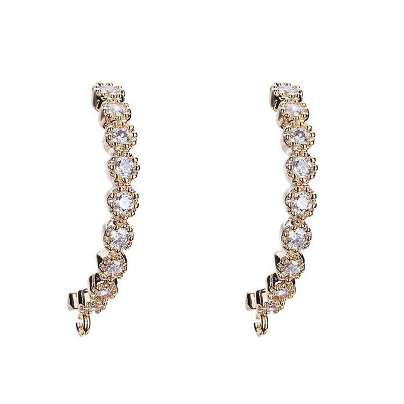 May include: A pair of gold hoop earrings with a row of clear cubic zirconia stones around the hoop.