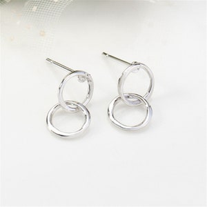 May include: Silver double circle earrings with a small clear stone accent.