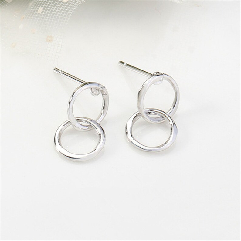 May include: Silver double circle earrings with a small clear stone accent.
