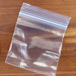 May include: A clear plastic zip-lock bag with a white zipper.