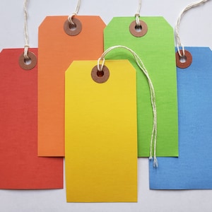 May include: Five blank gift tags with string attached. The tags are in different colors: red, orange, yellow, green, and blue.
