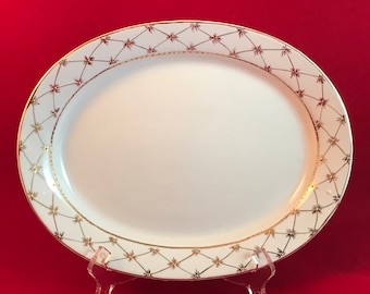 May include: White oval serving platter with a gold and brown geometric design around the edge.
