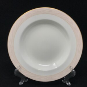May include: A white porcelain soup bowl with a wide, shallow rim. The bowl has a pink and gold decorative border.