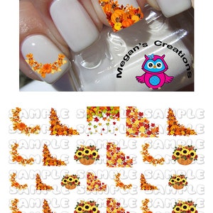 May include: Fall-themed nail art stickers with designs featuring pumpkins, sunflowers, and autumn leaves in shades of orange, yellow, and red. The stickers are arranged in a grid pattern on a white background. The text "Megan's Creations" is visible in the top right corner of the image.