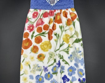 L'asciugamano da cucina Hang è realizzato in morbida spugna di cotone con fiori colorati e cotone a fantasia floreale blu.