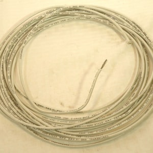 Peut inclure: Gros plan d'une bobine de fil électrique blanc avec du texte noir qui se répète plusieurs fois : "CONTINENTAL 3RD 14 AWG AWM STYLE 3079".