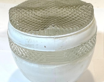 May include: A vintage, clear glass light fixture with a white base. The top is a diamond-patterned, triangular shape. The base has a decorative band with a diamond pattern. The fixture is likely for a ceiling or wall.