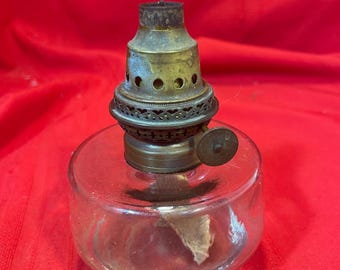 Lámpara de aceite colgante de cristal antiguo con base redonda y quemador central de tiro brillante.