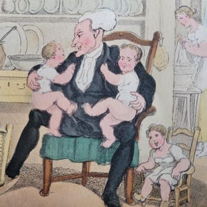 Peut inclure: Un homme avec une perruque blanche est assis sur une chaise tenant deux bébés sur ses genoux. Les bébés portent des robes blanches. L'homme porte un costume noir et une chemise blanche. Il y a un panier en arrière-plan et une femme debout dans l'embrasure de la porte.