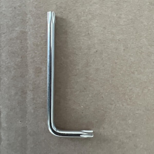 May include: A silver L-shaped Allen wrench with a star-shaped head.