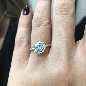 Pu&ograve; includere: Un anello d'argento con un grande diamante solitario rotondo e trasparente.