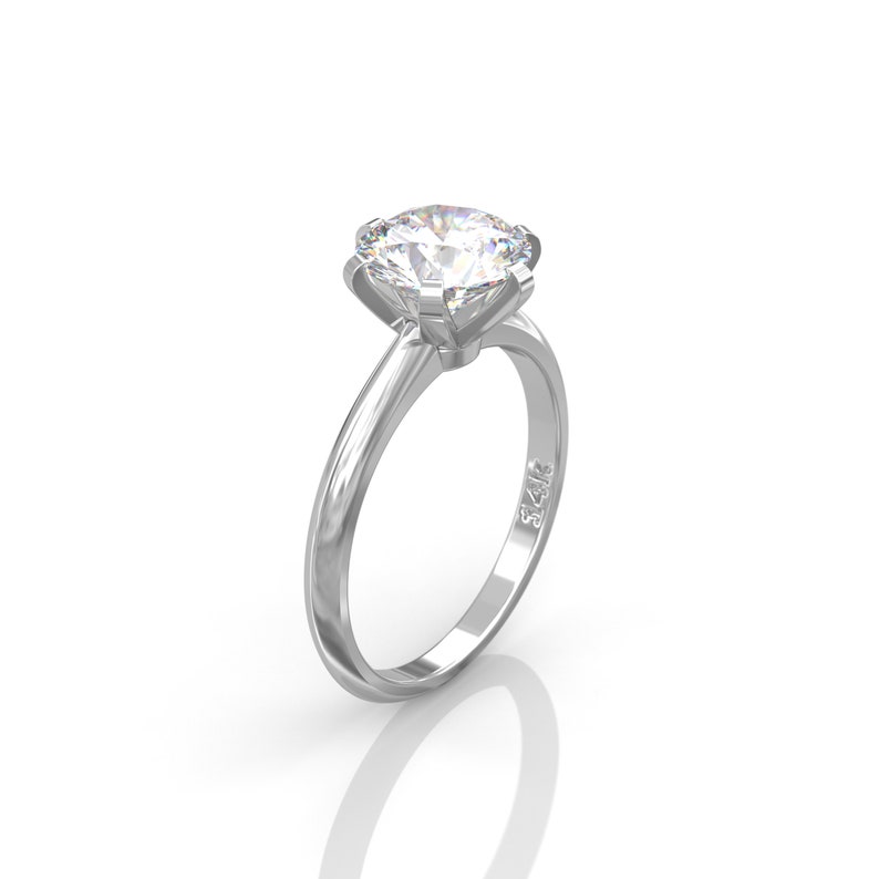 Pu&ograve; includere: Un anello di fidanzamento in argento con un grande diamante rotondo e trasparente. L'anello &egrave; contrassegnato "14K" sulla fascia interna.