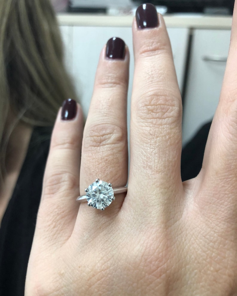 Pu&ograve; includere: Un anello d'argento con un grande diamante solitario rotondo e trasparente.