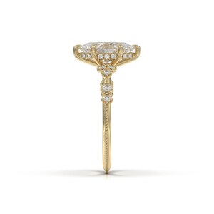 May include: A gold engagement ring featuring a large oval-shaped diamond centre stone, surrounded by a halo of smaller diamonds. The band is also set with smaller diamonds.