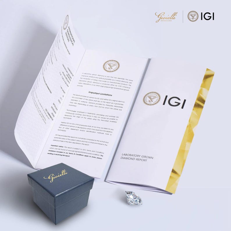 May include: A diamond, a dark blue jewelry box with the word "Gioielli" in gold script, and a Laboratory Grown Diamond Report are displayed. The IGI logo is visible on the report. The diamond is faceted and clear.