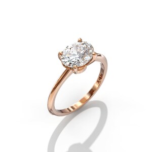 May include: A rose gold engagement ring with a large oval-shaped diamond set in a four-prong setting.