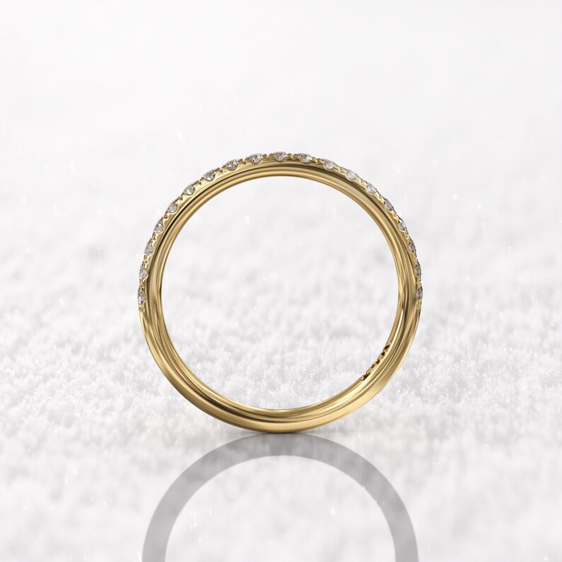 May include: A thin gold band with a row of small diamonds set in a pave setting.