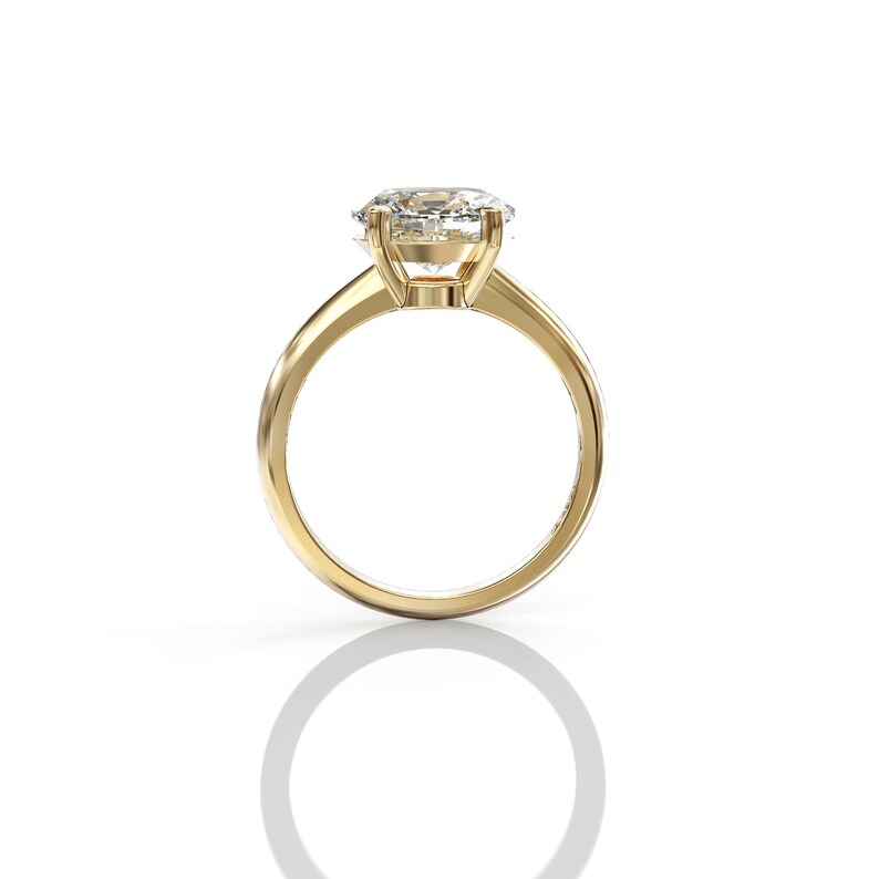 May include: A gold engagement ring with a large, clear, oval-shaped diamond.