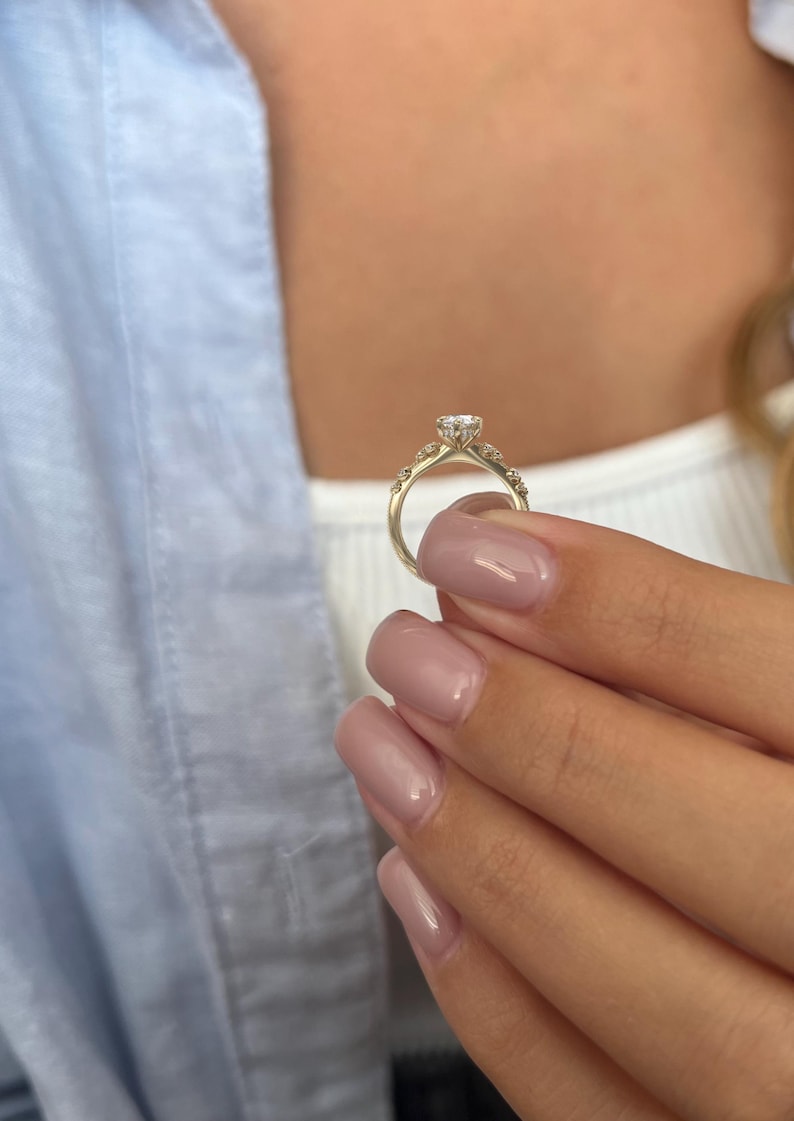 May include: A gold engagement ring with a single large diamond and smaller diamonds set in the band.