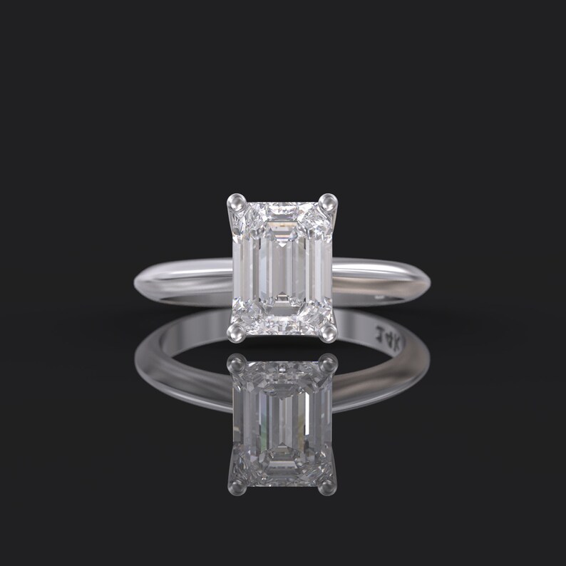 Pu&ograve; includere: Un anello di fidanzamento in argento con un grande diamante a taglio smeraldo trasparente.