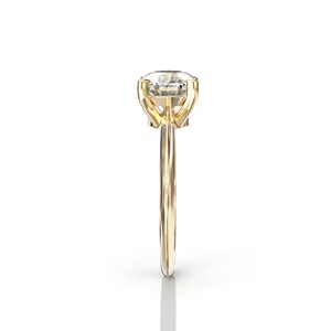 May include: A gold engagement ring with a large, clear, oval-shaped diamond.