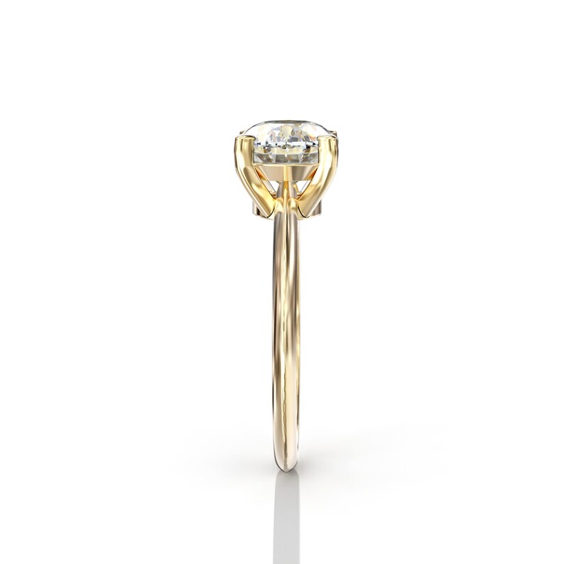 May include: A gold engagement ring with a large, clear, oval-shaped diamond.